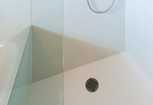 Zu einem barrierefreien Bad gehört eine bodenebene Dusche, ein unterfahrbarer Waschtisch, Haltegriffe und rutschfeste Matten.